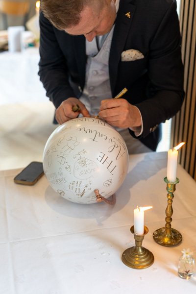 Häävieras kirjoittaa maapalloon tervehdystä hääparille.
